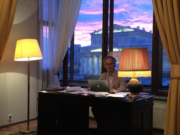 author Amor Towles sitting at a desk in his room at the Metropol
