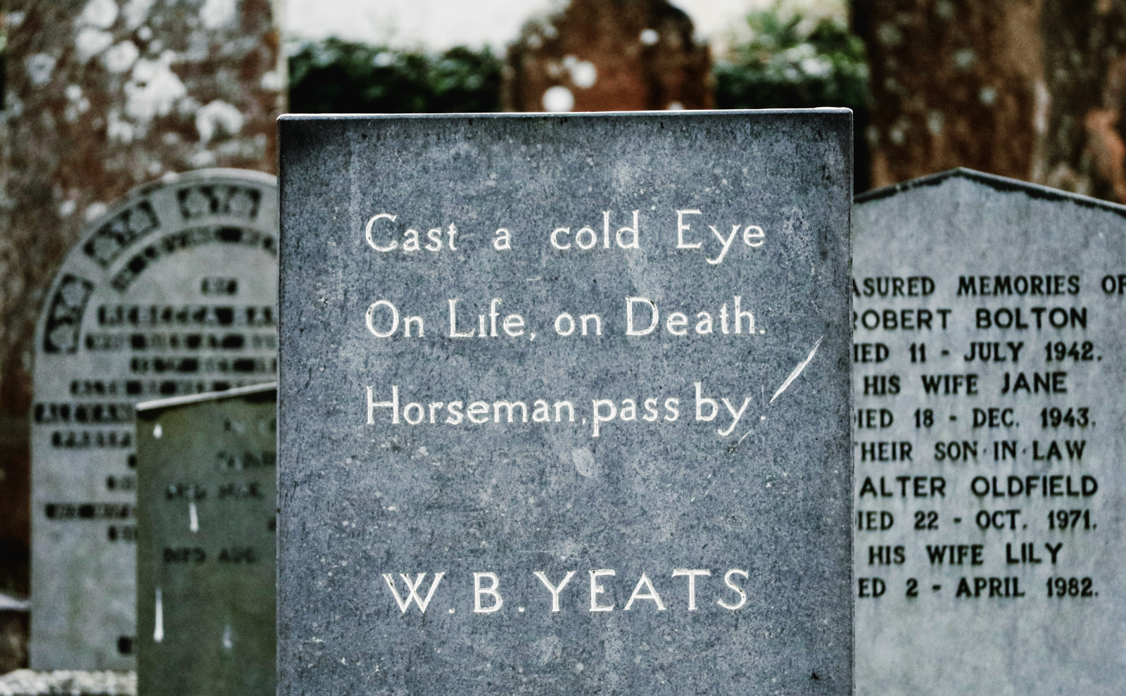 gray tombstone at wb yeats tomb that says cast a cold eye on life on death / horseman pass by