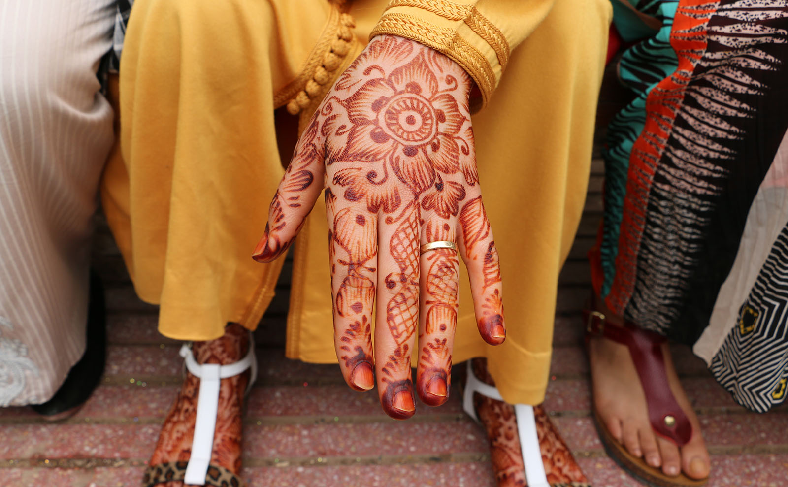 a woman's hands displaying red henna tattoos