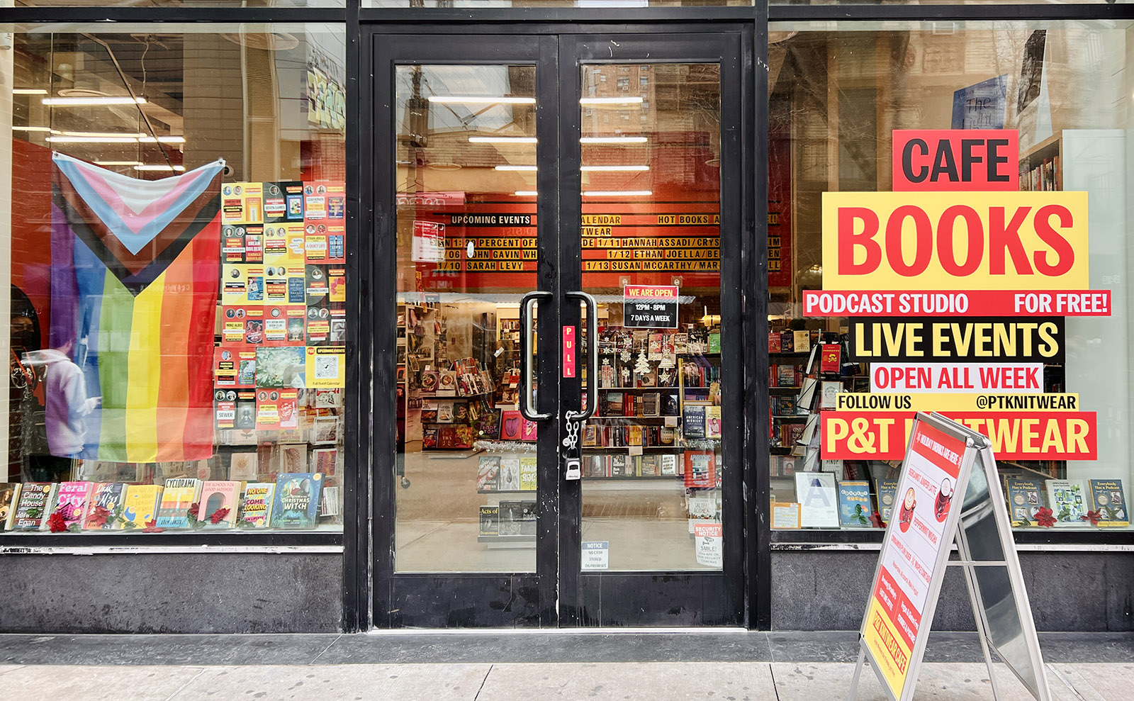 front door of the bookshop with large glass windows where books can be seen on shelves inside
