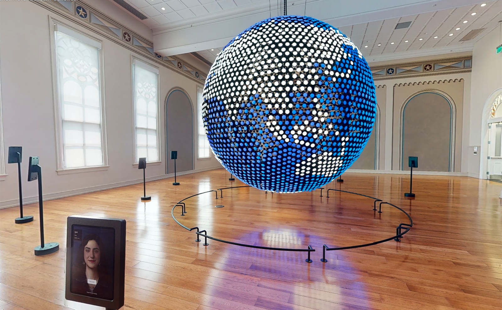 open airy room with an enormous globe made of lights in the center