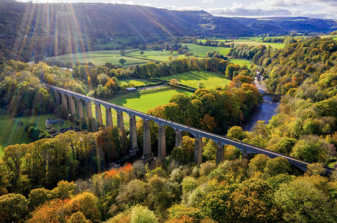 arched aquaduct over a river on a sunny day