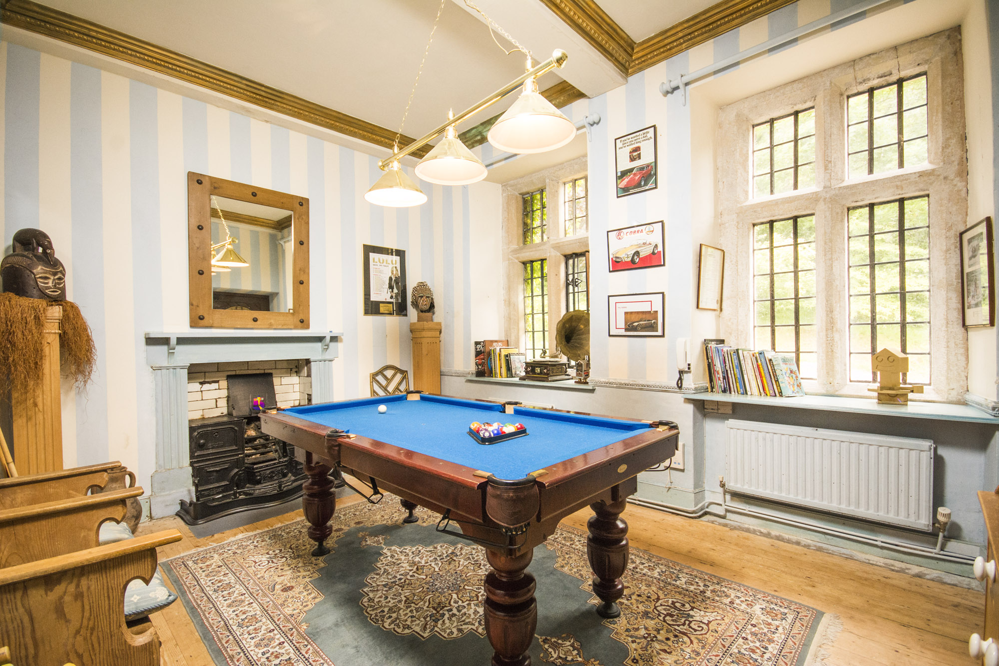 a room with wooden paneling and a blue billiard table