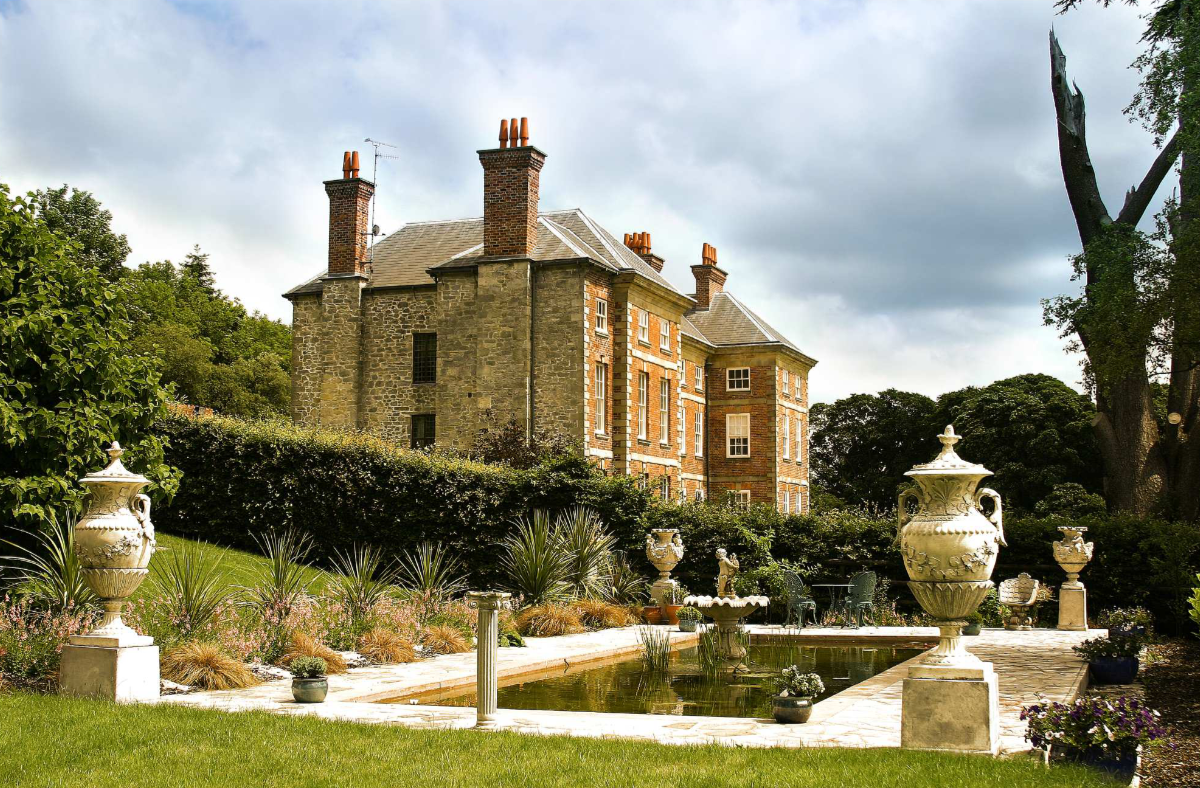 lily pond and trees with a georgian mansion in the background