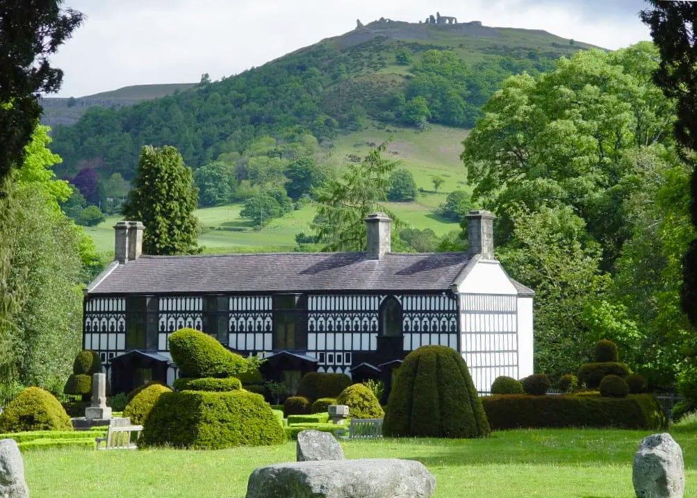 black and white gothic cottage surrounded by lawns