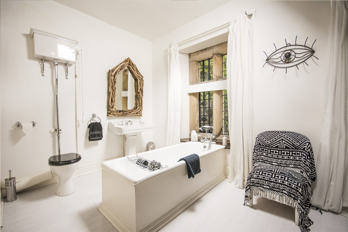 a white bathroom decorated with a wire sculpture