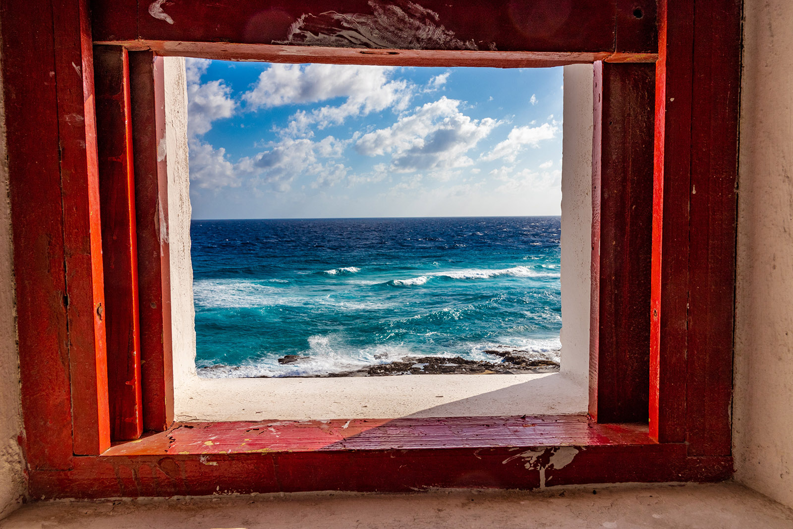 view of the blue ocean through a window