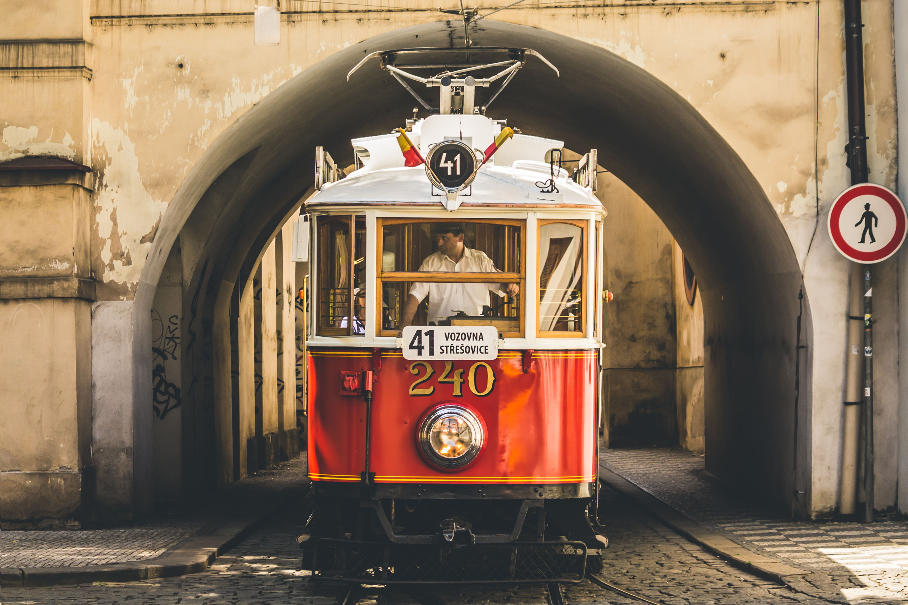 tram pulling through an arch in prague
