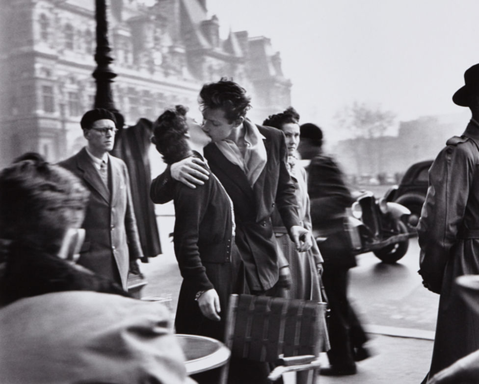 black and white photo of a man and woman kissing in paris