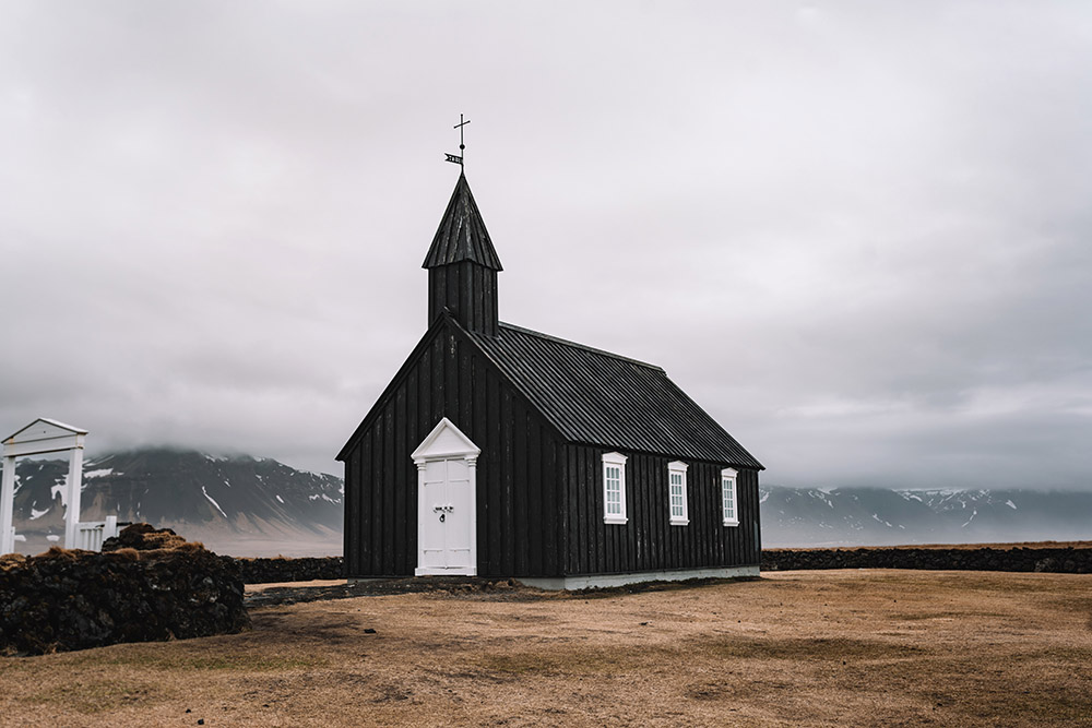 small black church in iceland in the middle of a lava field