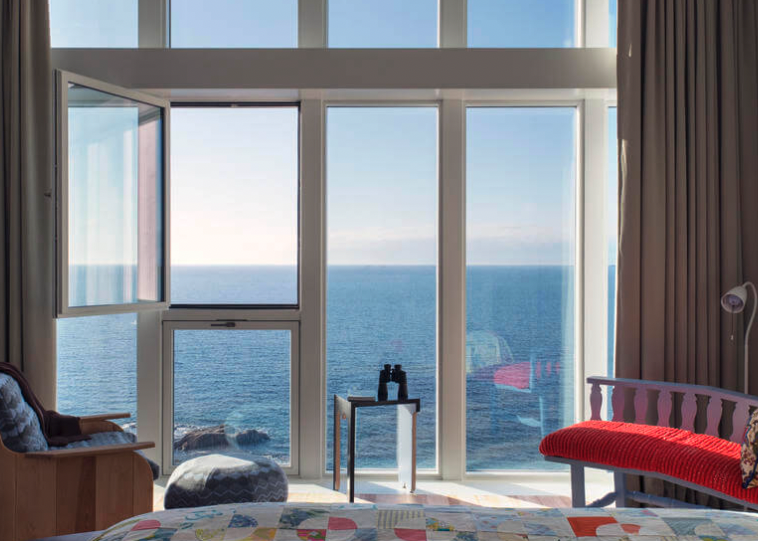 hotel room with floor to ceiling windows overlooking the atlantic ocean
