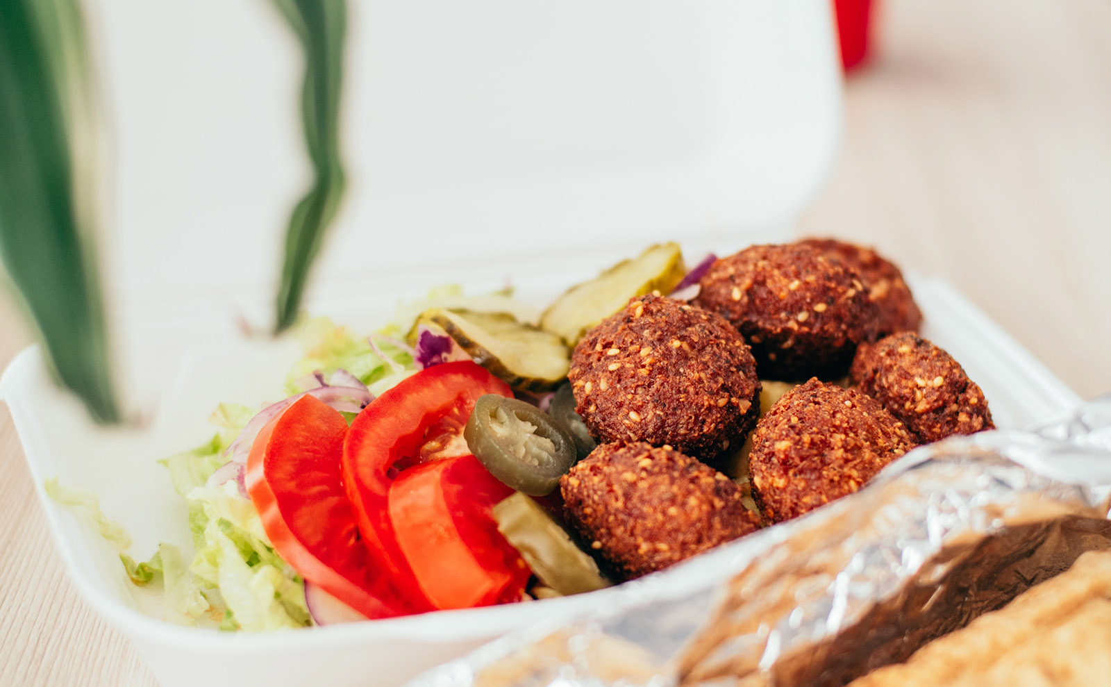falafels on a dish with tomatoes and pickles
