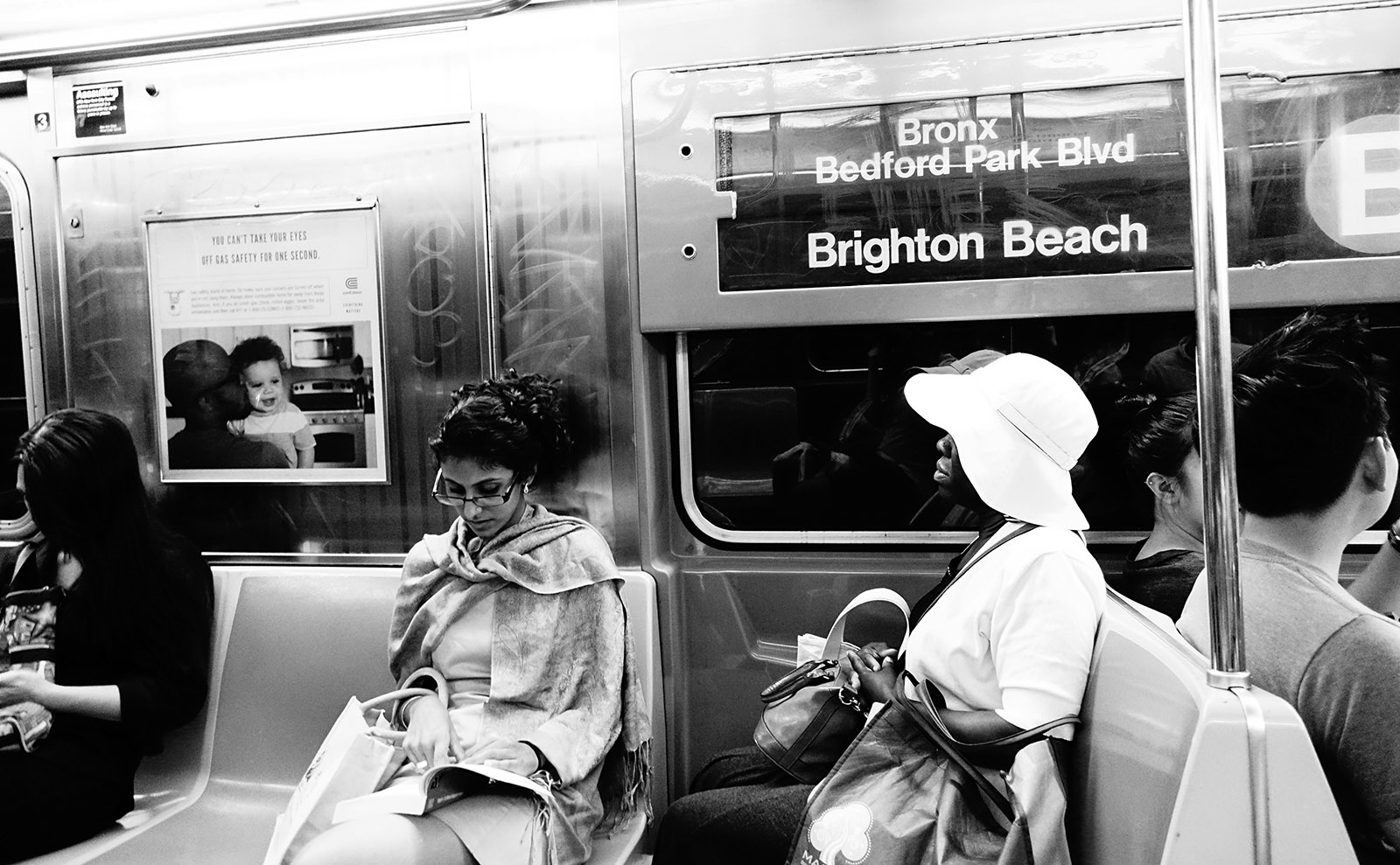 black and white photo of two women sitting on the new york city subway