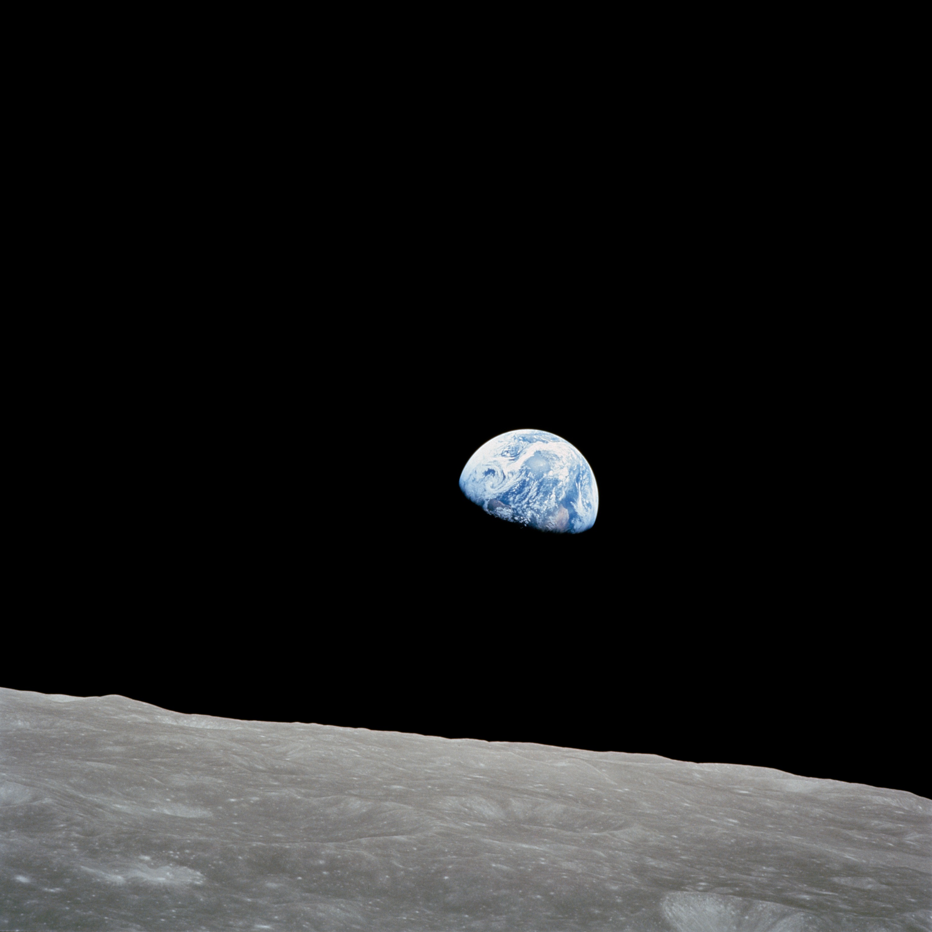 the earth seen from space looking like a blue and white marble in a black sky