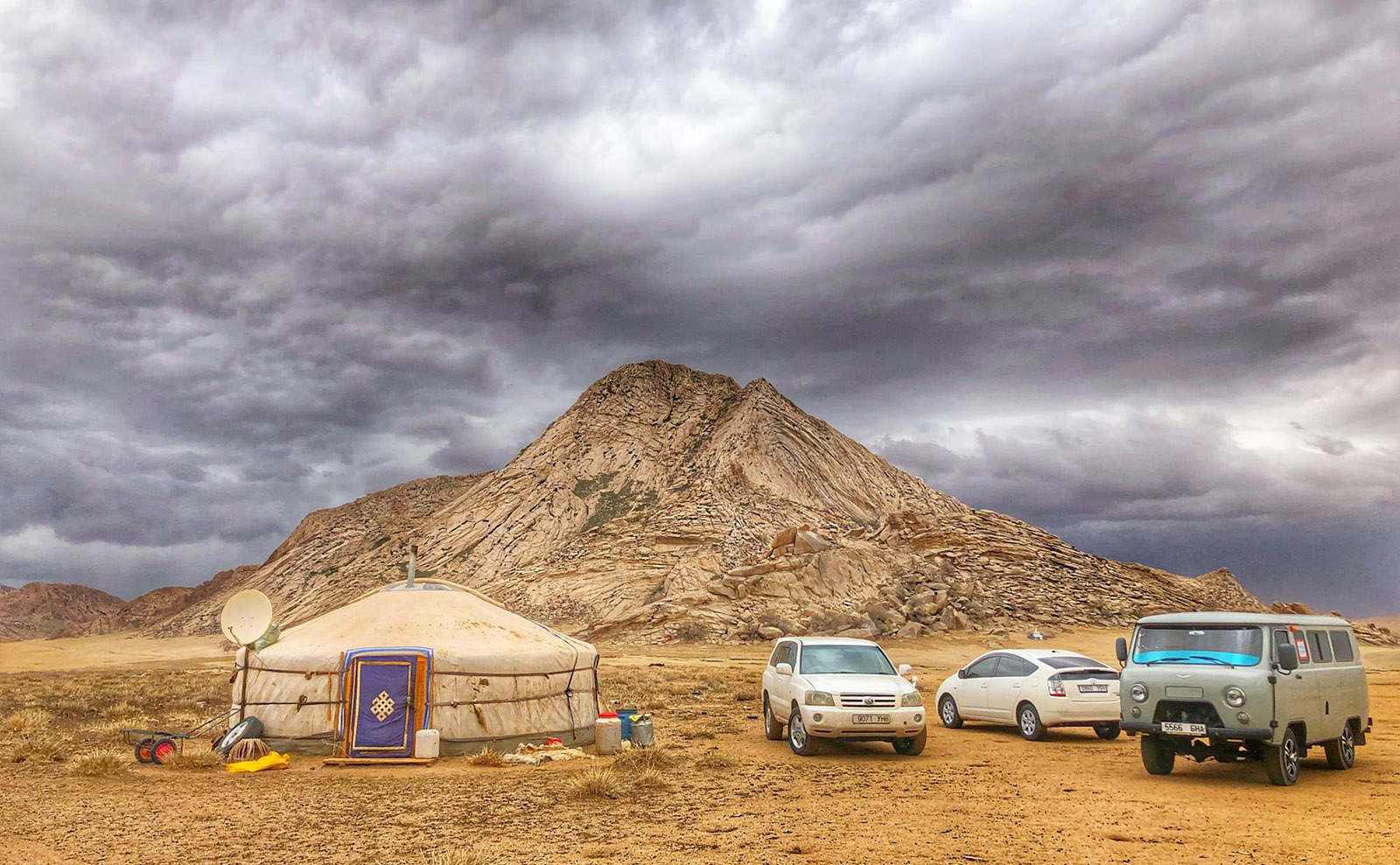 yurts and jeeps parked in the middle of an open plain