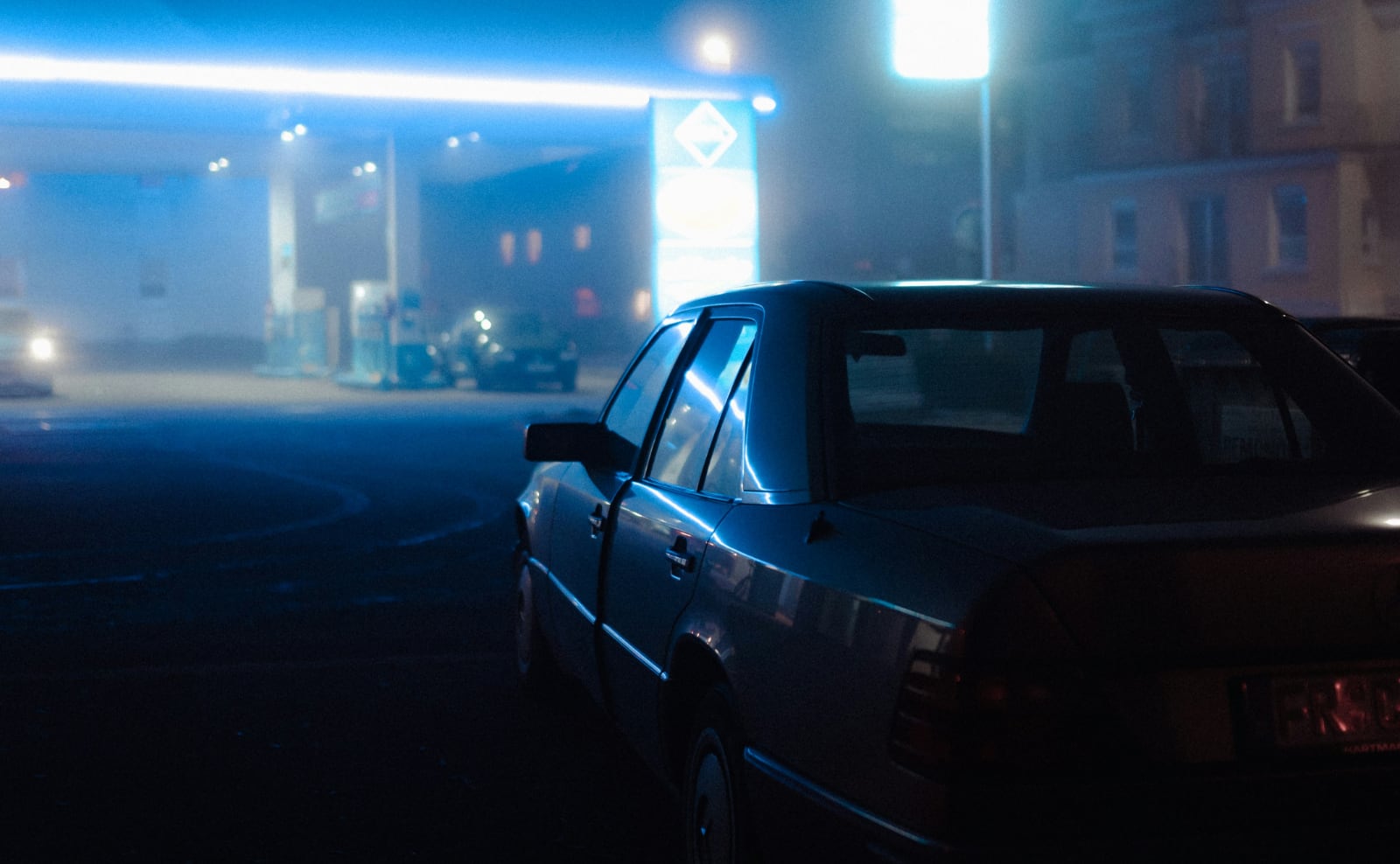 a late model sedan on a city street on a foggy night