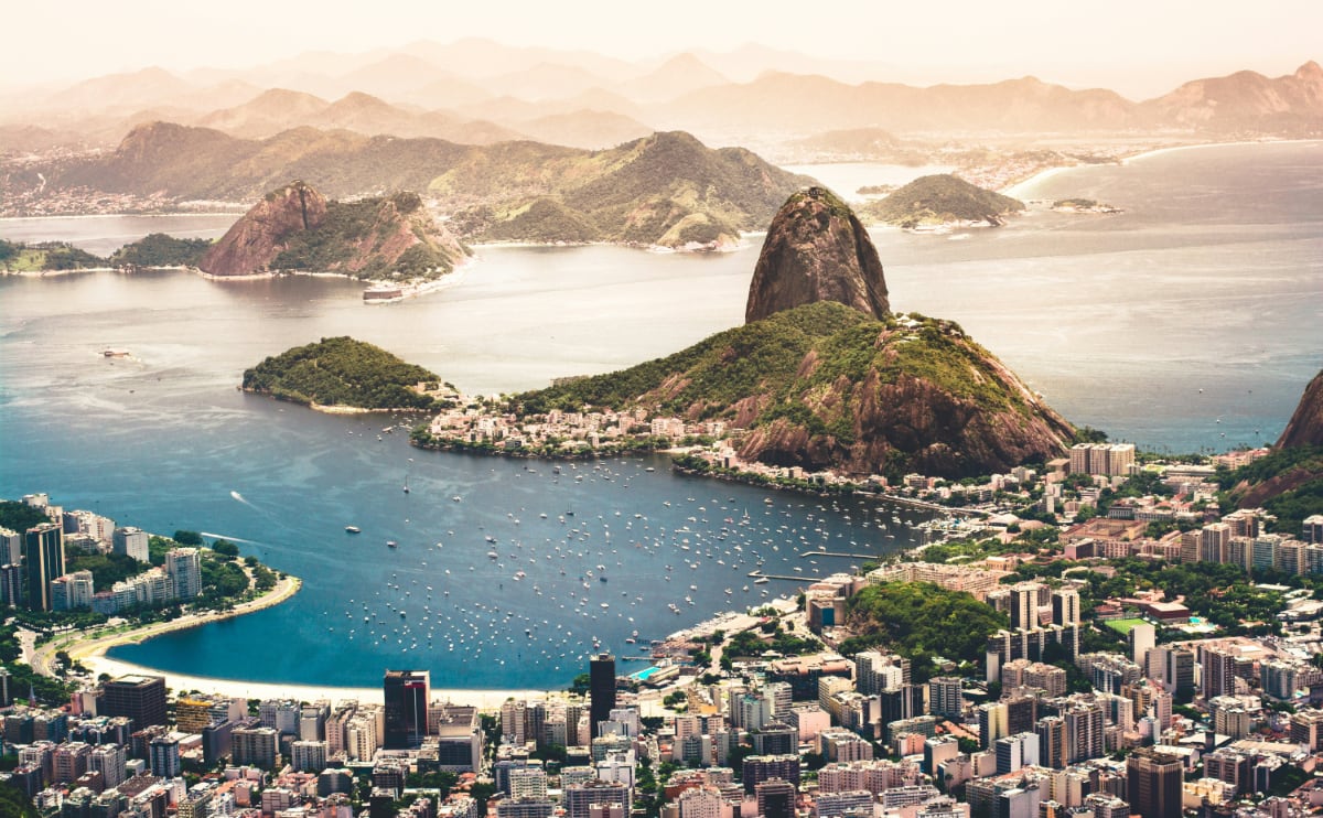 aerial view of rio de janeiro in brazil with cityscape, ocean, and mountains under a sunny sky