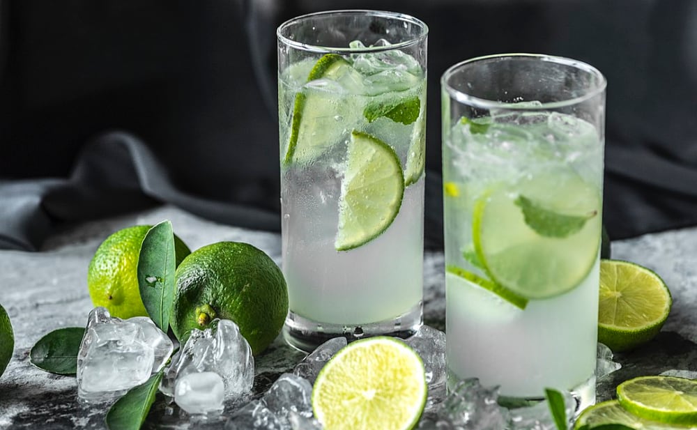 two glasses of liquor with slices of lime