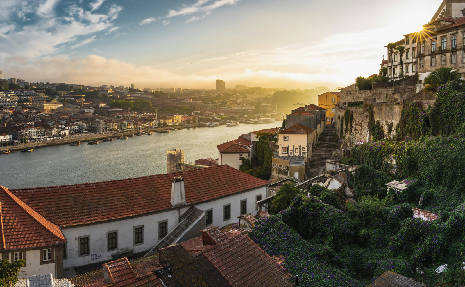 white houses with red tiles roofs on a hill overlooking a river