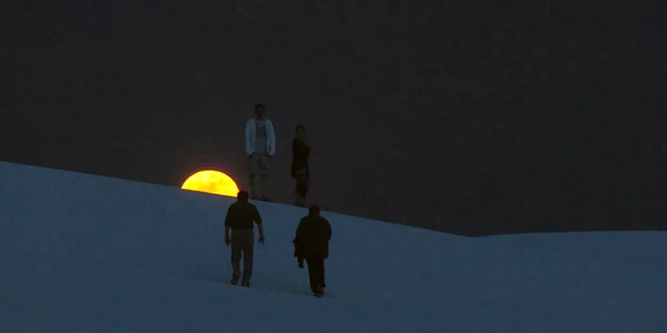 giant yellow moon in a black sky over the sandy desert