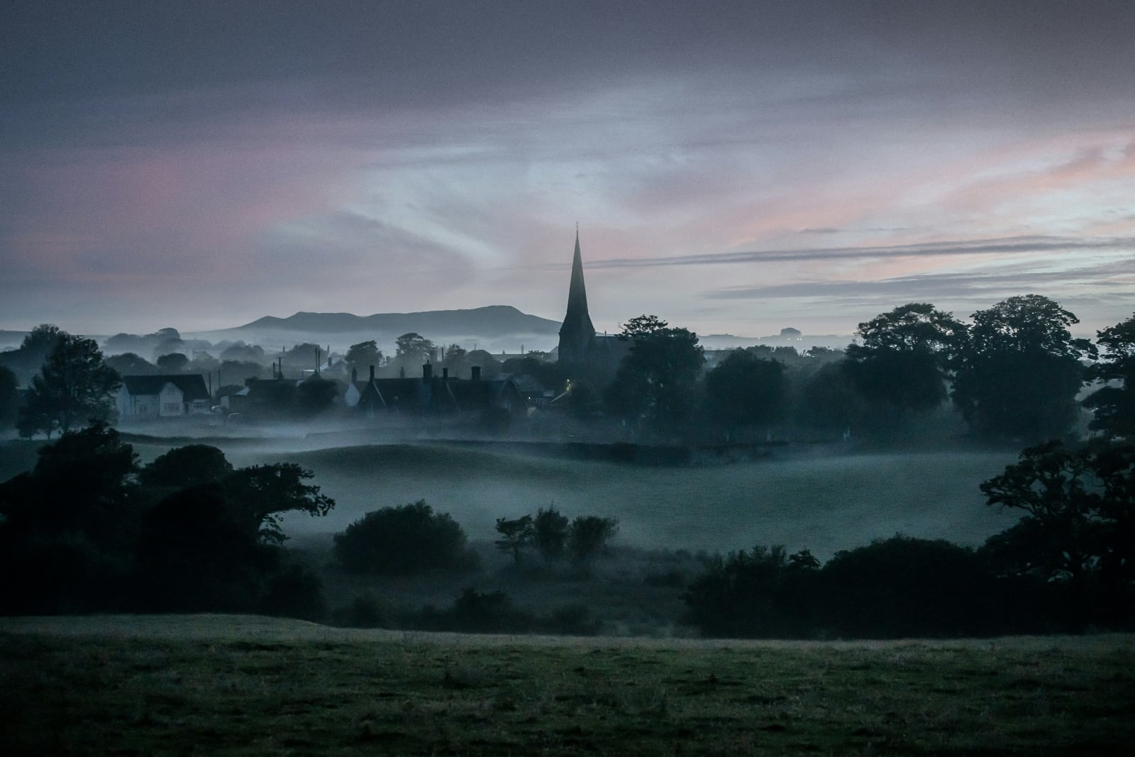 church spires rising out of the mist in a village