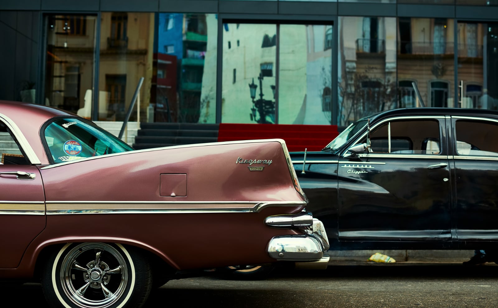 two shiny muscle cars on the street of Detroit