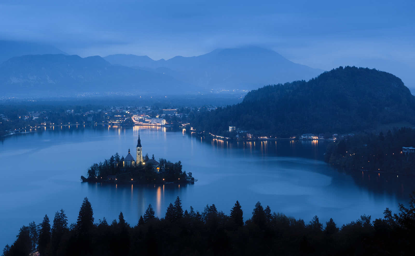 small island in lake bled with a white church at night
