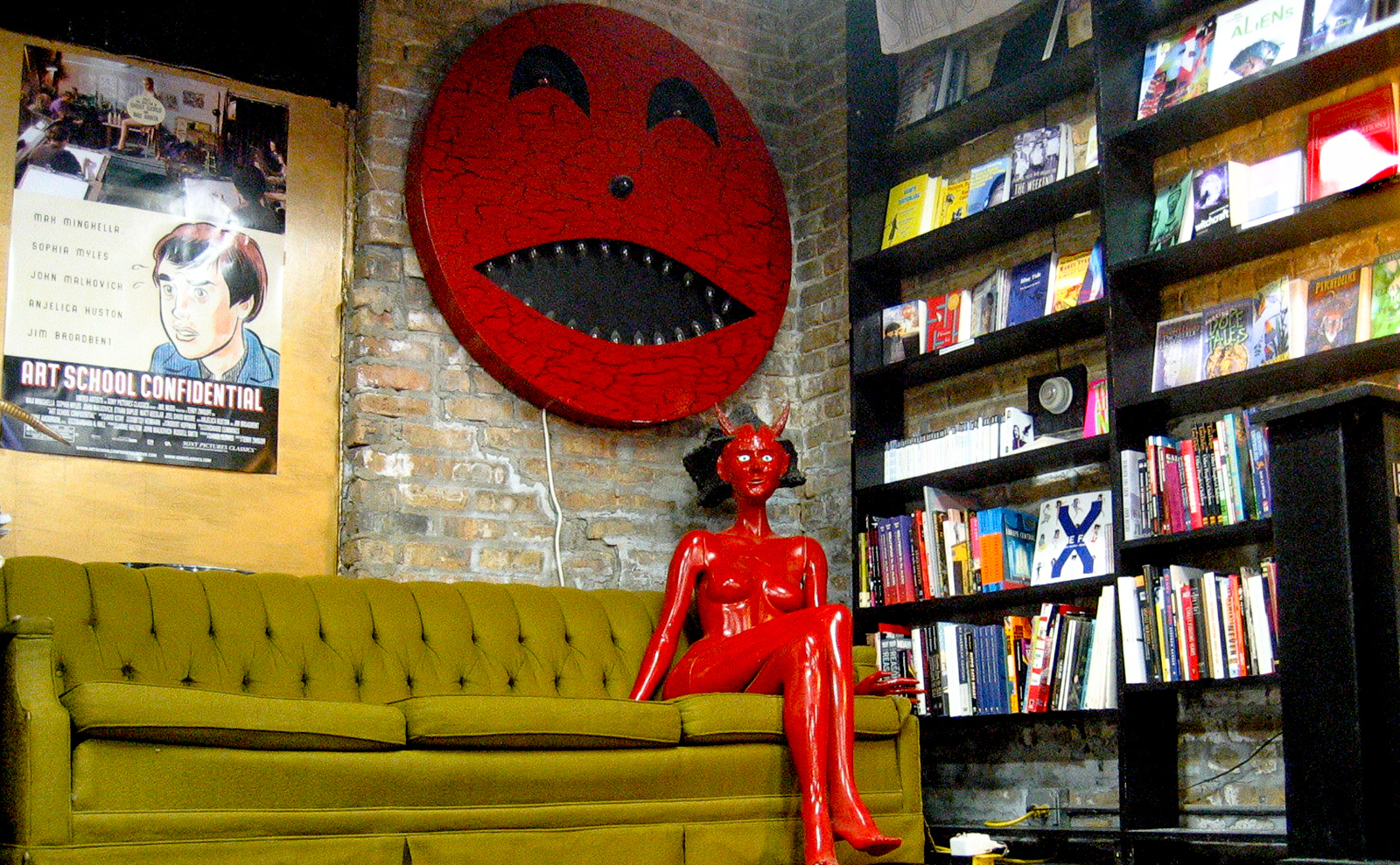stage area in quimby's with green couch and red lady-devil mannequin