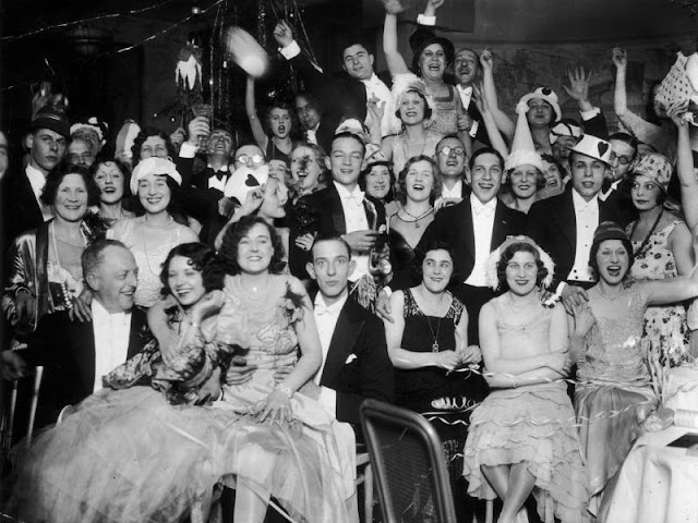  black and white photo of a large group of people celebrating new year's eve in 1920s formal clothing