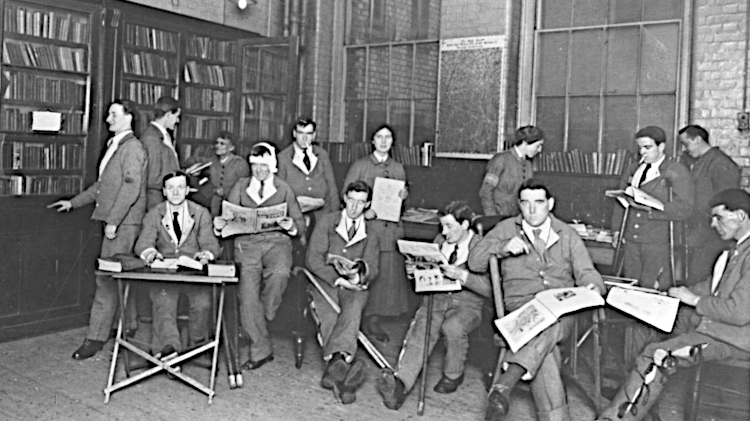 black and white photo of young, injured soldiers reading books