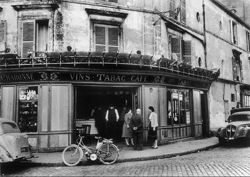 black and white photo of a paris cafe with outdoor tables