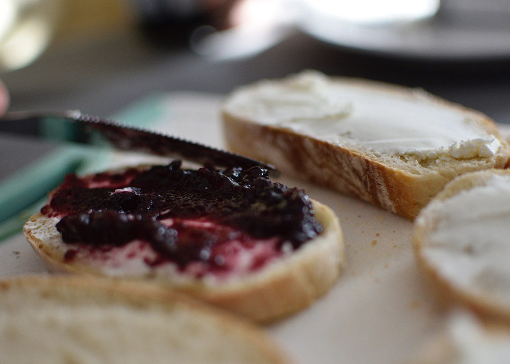 close up of bread spread with butter and jam
