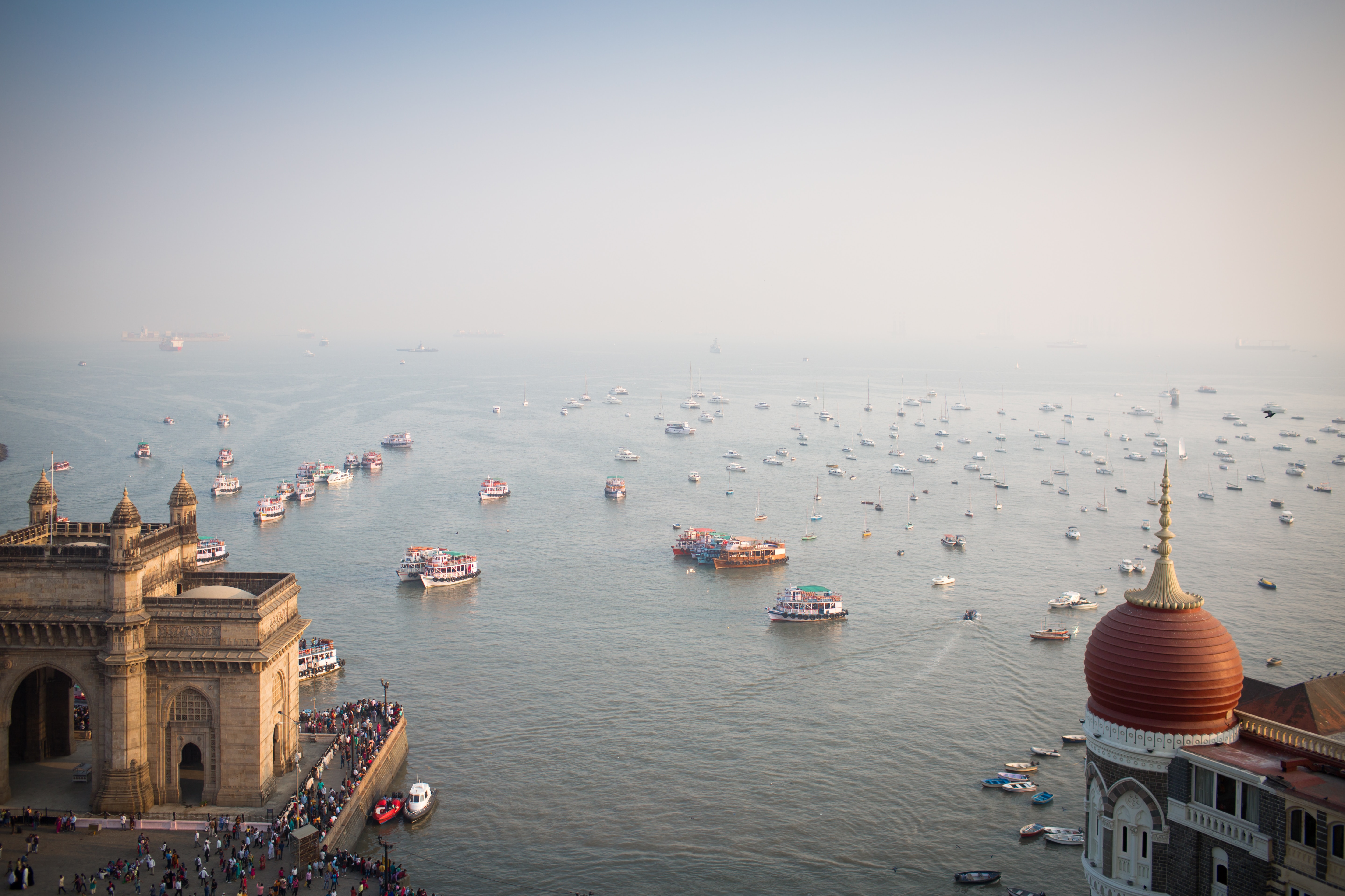 boats on the water in front of the gateway of india in mumbai
