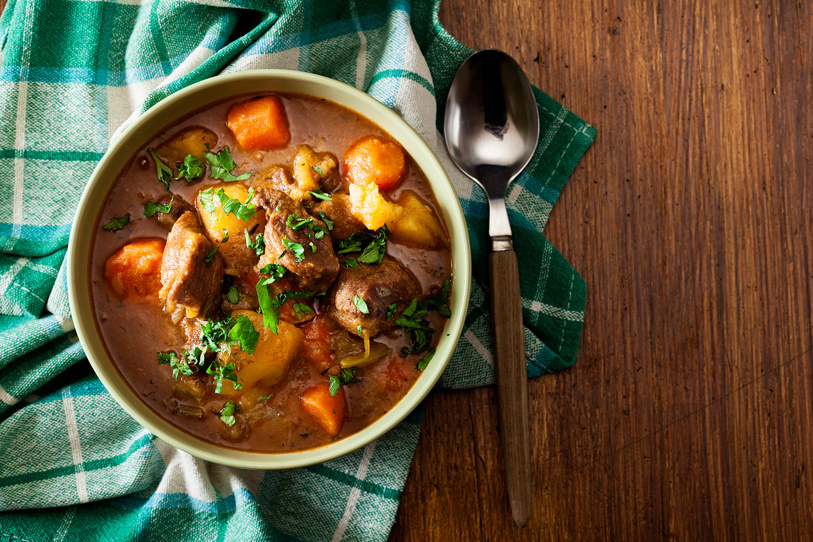 bowl of irish stew on a wooden table