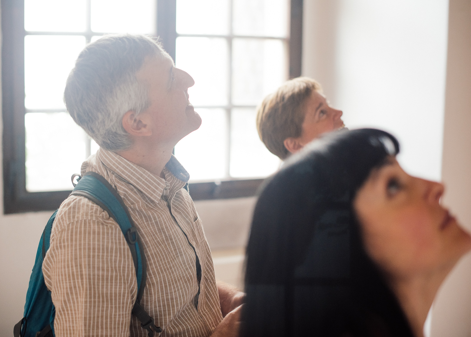 three people looking at up at the ceiling in the Theological Hall