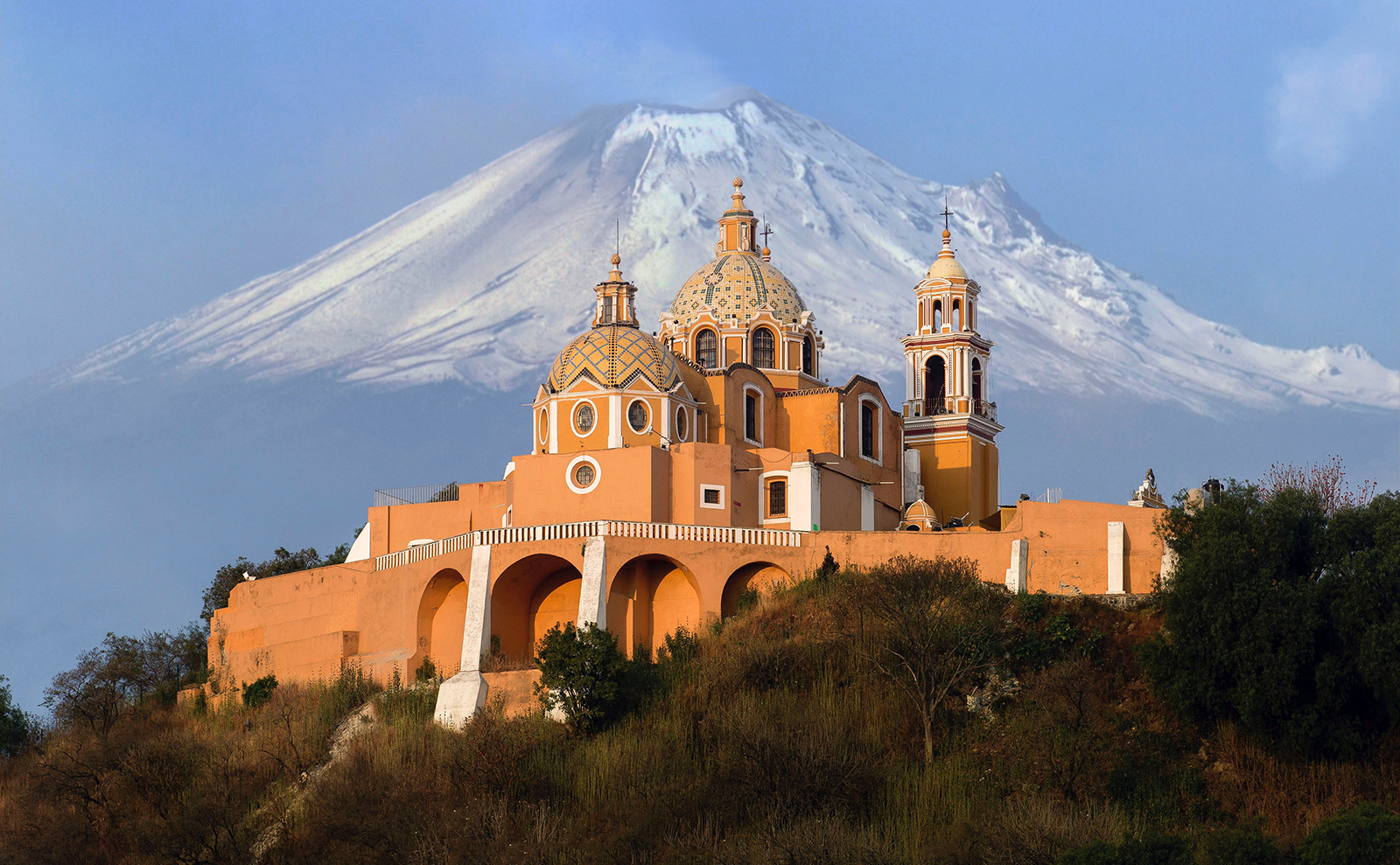 peach-colored Santuario de la Virgen de los Remedios church with domes in San Pedro Cholula, Mexico