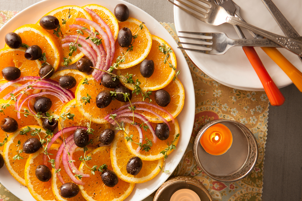 orange slices and black olives arranged on a plate