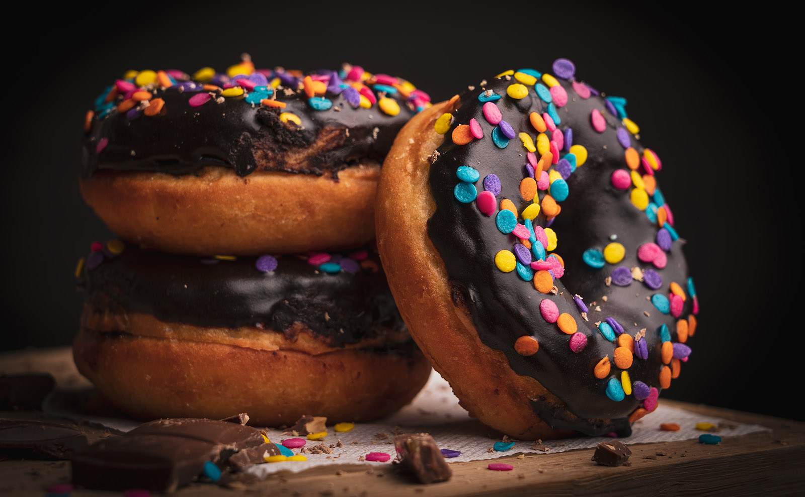 donuts with chocolate frosting on a wooden board