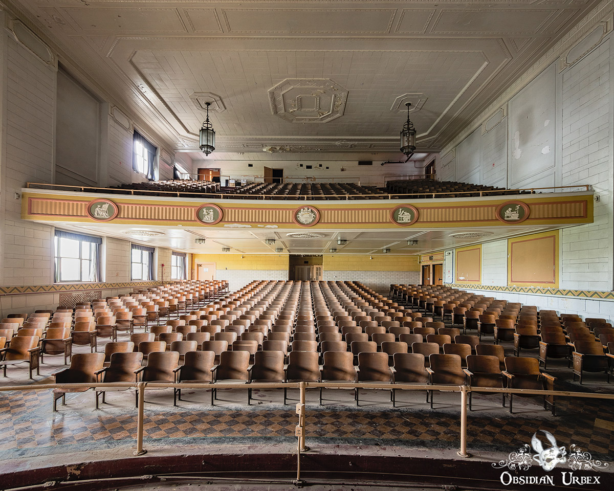 abandoned auditorium with stage and rows of seats