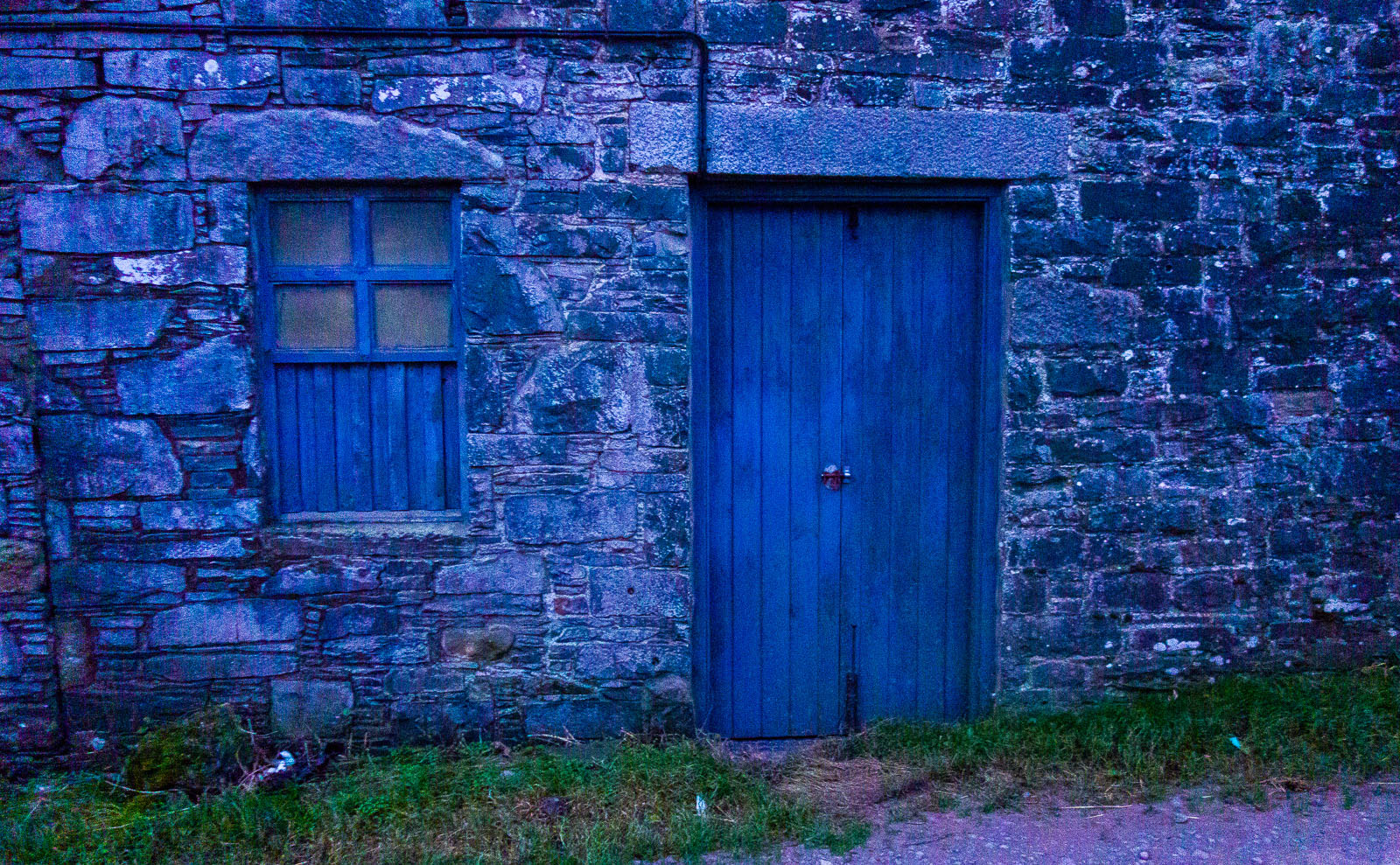 a blue wooden door set in a stone wall