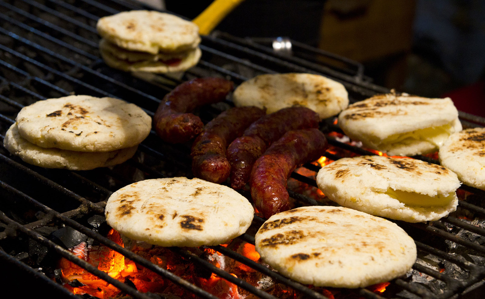 arepas and chorizo on a grill