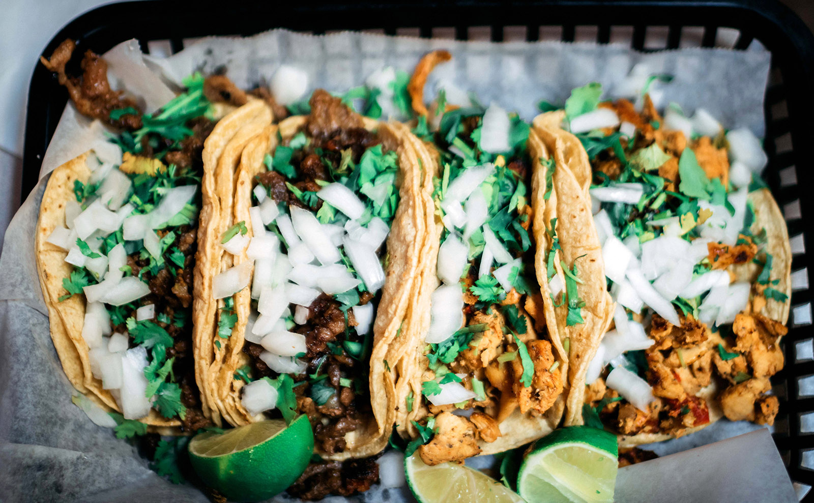 platter of soft tacos with onion and cilantro