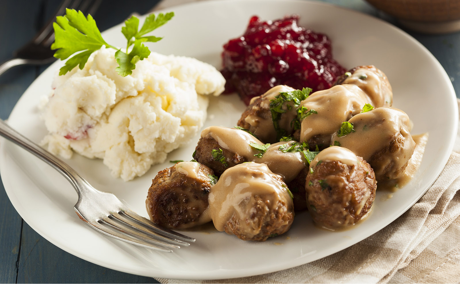 swedish meatballs in gravy with mashed potatoes and lingonberry jam