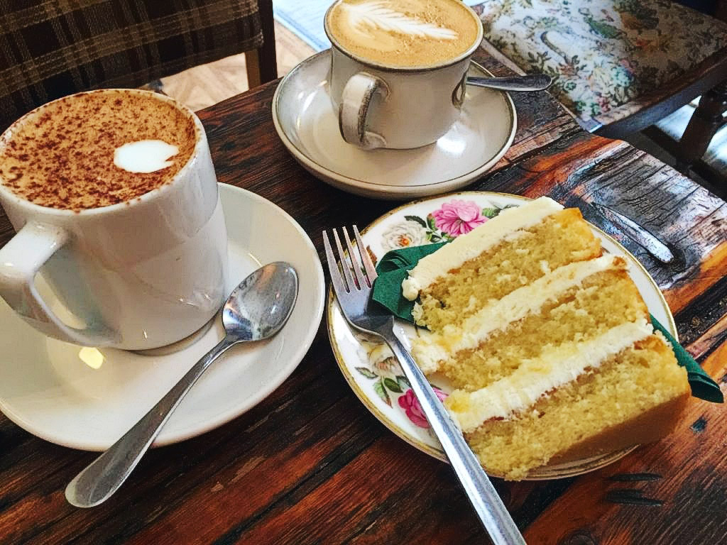 two cappuccinos with a large slice of layer cake
