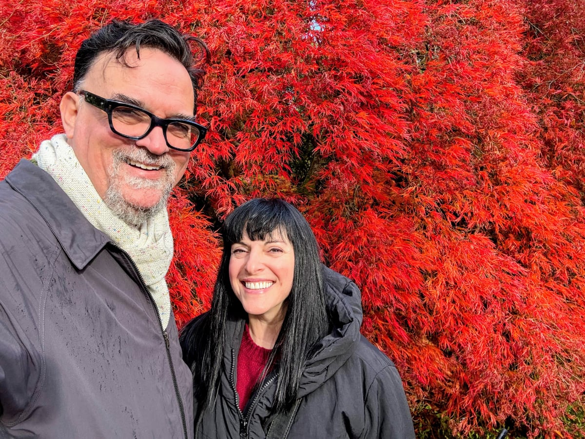 man and woman standing in front of a red tree