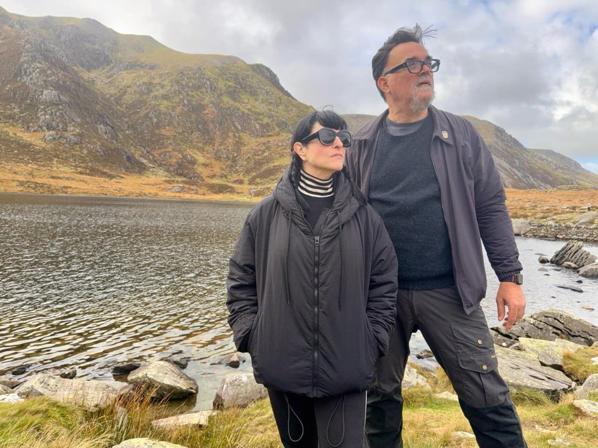 man and woman in active wear standing by a lake